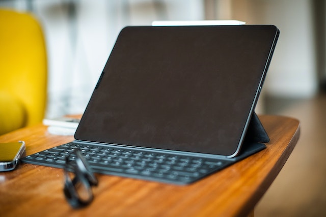 Tablet with a keyboard attached sitting open on a wood table