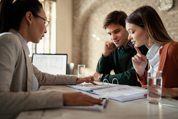 Tax specialist reviewing a document with a couple across the table
