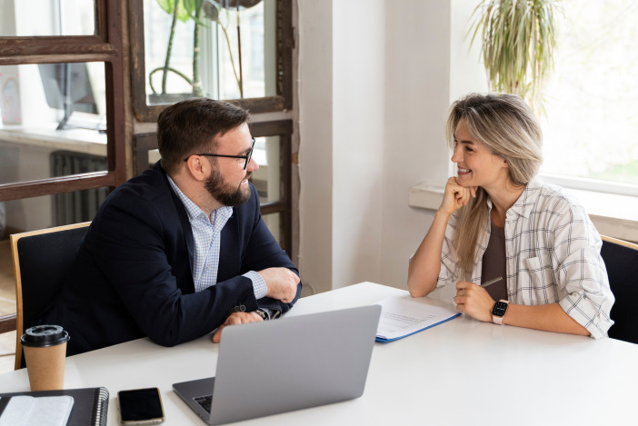 Two people sitting at a table together having a discussion