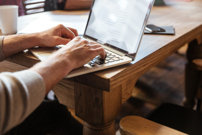 Close up of hands typing on a laptop