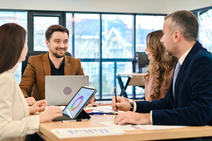 Four people sitting around a desk working together