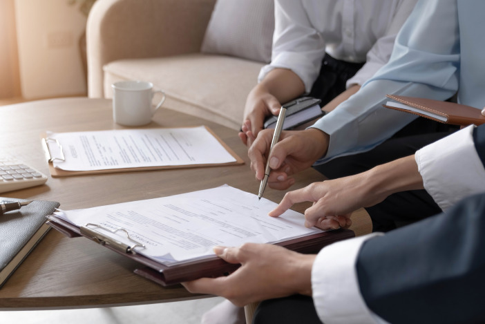 Close up of two people's hands pointing at a document